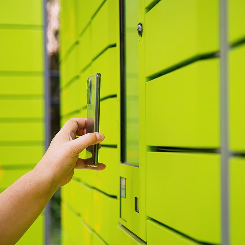 Hand holding up mobile phone to intelligent locker