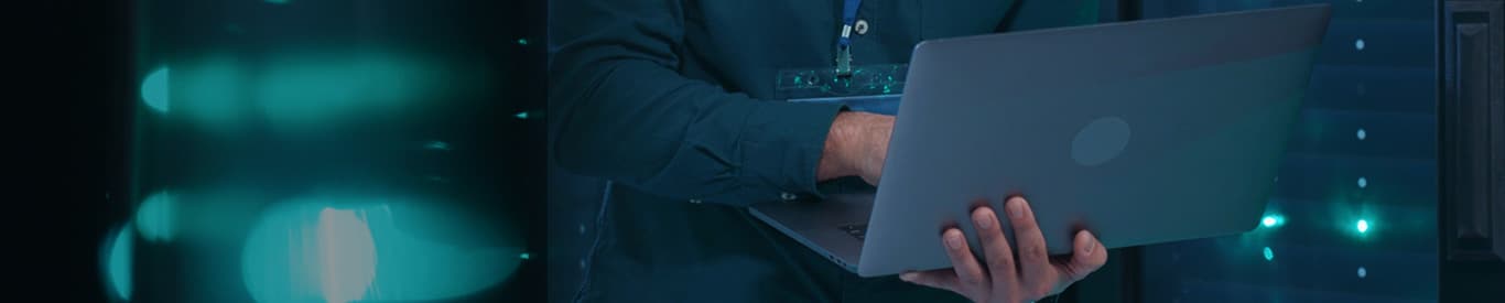 man consulting laptop in server room