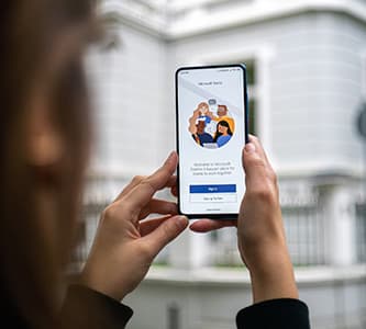 person holding up phone with MS Teams on the screen